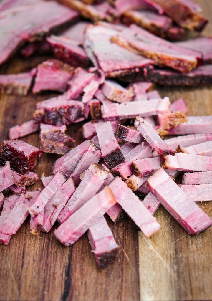 Diced brisket on a brown cutting board. 