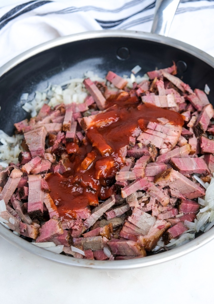 Diced brisket with onion and chipotle sauce in a saucepan. 