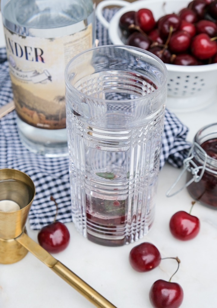 Cherry syrup added to tall clear glass to make a cherry mojito