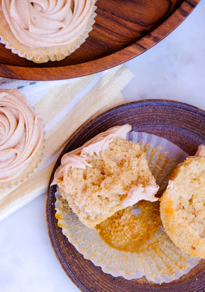 Top view of churro cupcake on a brown plate cut in half. 