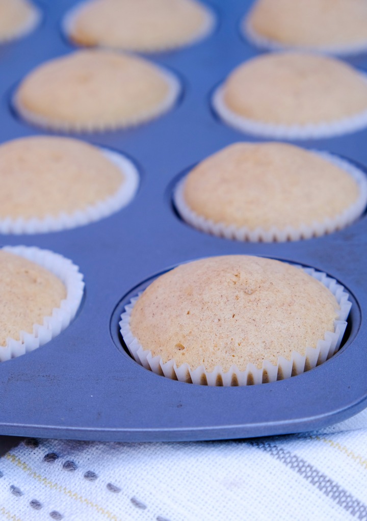 Baked cupcakes in cupcake baking tin cooling.