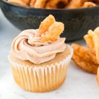 Churros cupcake topped with a cinnamon twist ready to eat.