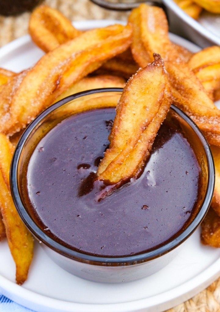 Chocolate sauce with a churro dipped in the center. 