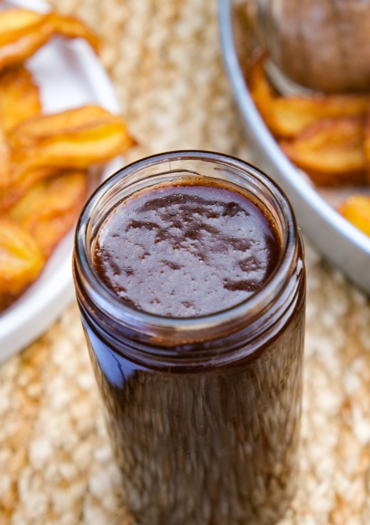 Homemade chocolate sauce in a clear glass jar. 