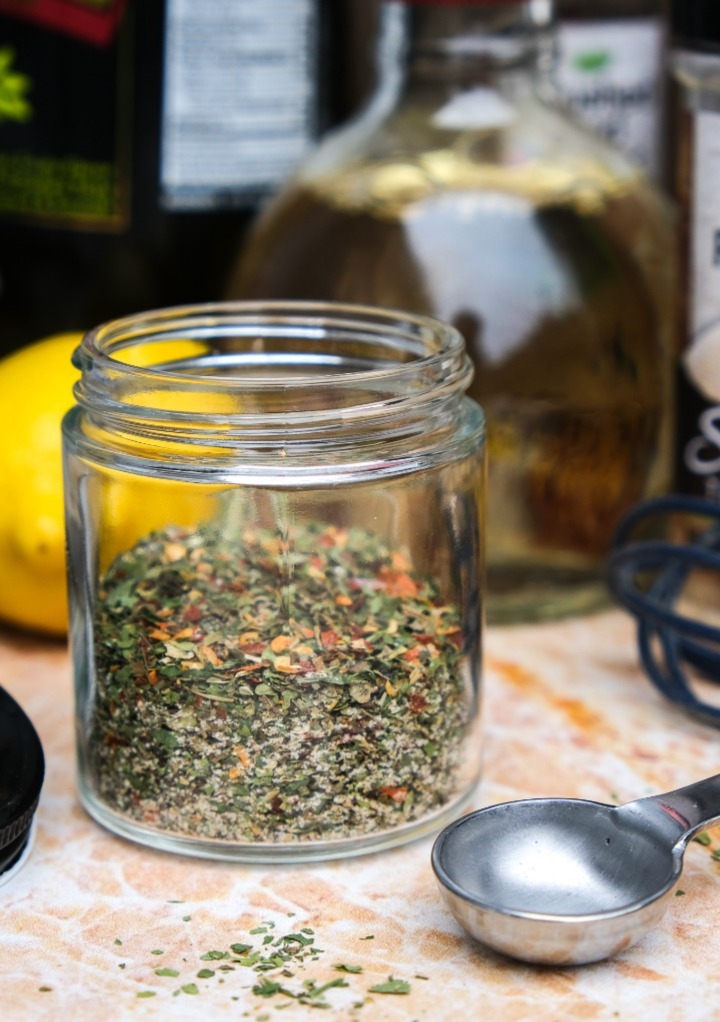 Dry spices in a small clear glass jar to make Italian dressing mix. 