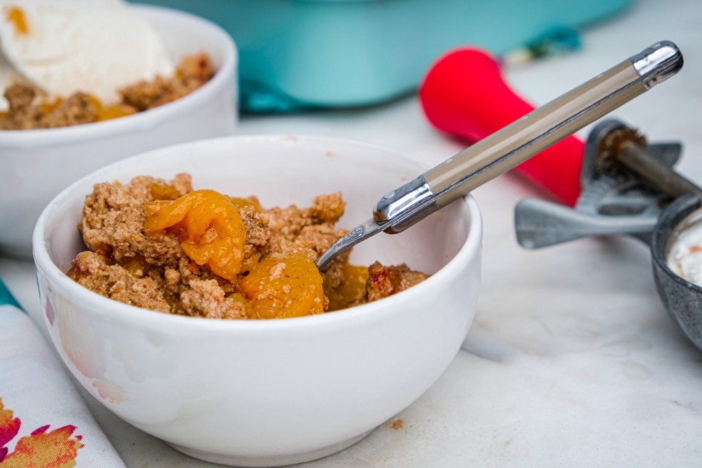 Sugar free peach crumble in a white serving dish. 