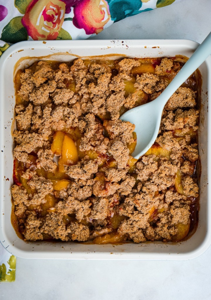 Peach crumble dessert in a small casserole dish. 