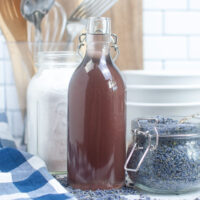 Homemade lavender syrup in a clear decanter for beverages.