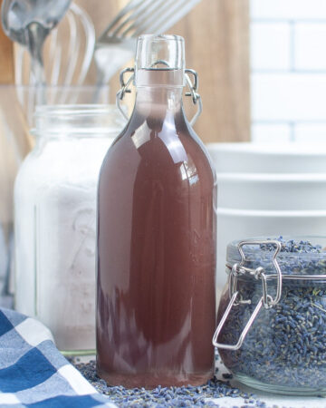Homemade lavender syrup in a clear decanter for beverages.