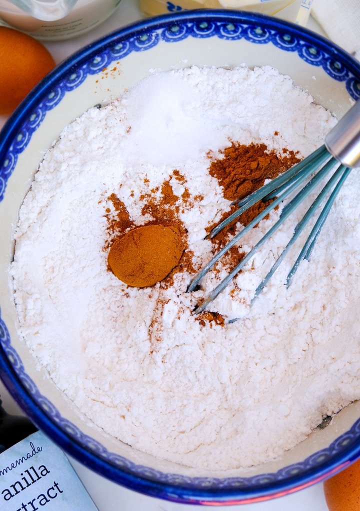 Whisking dry ingredients for cupcakes in a blue rimmed bowl. 