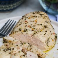 Skinless chicken breast cooked in Italian dressing on a serving dish.