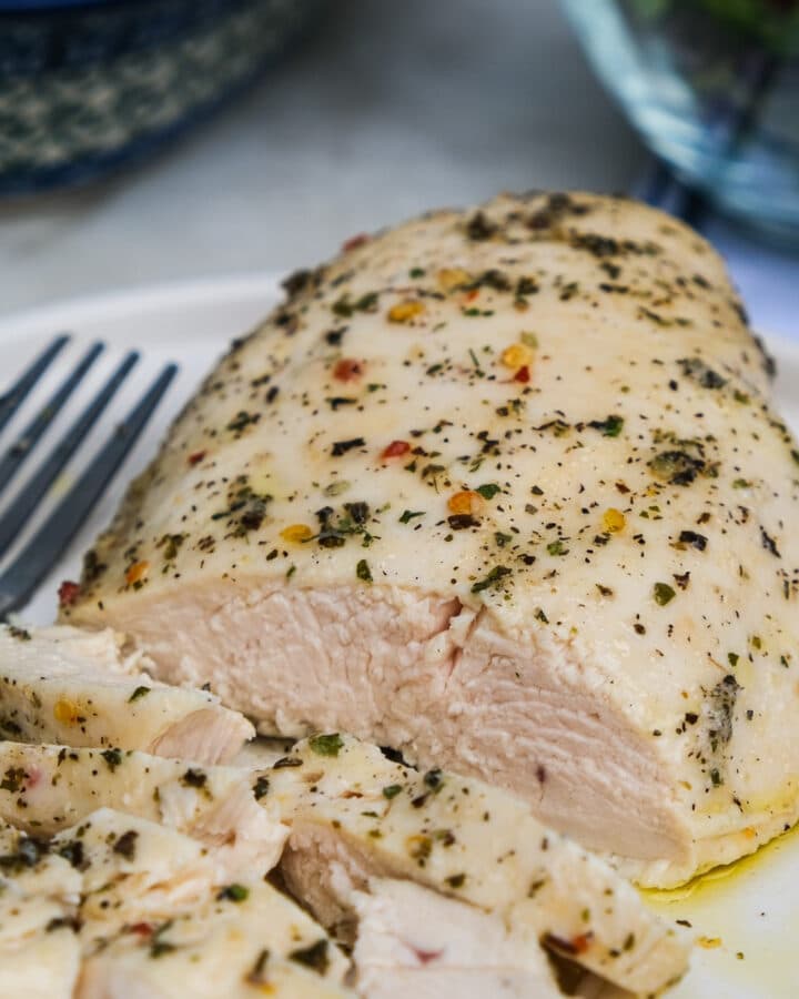 Skinless chicken breast cooked in Italian dressing on a serving dish.