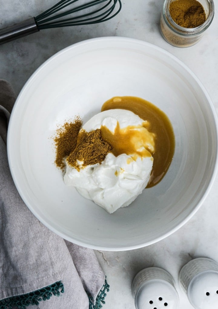 Yogurt dressing with curry in a white mixing bowl. 