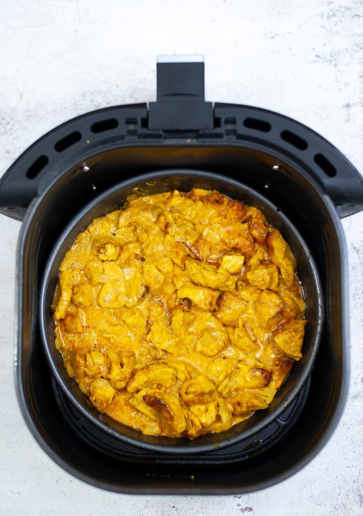 Curry chicken in an air fryer basket ready to serve up.