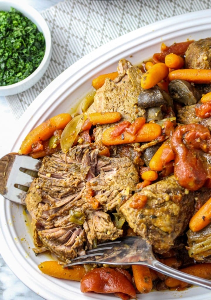 Pot roast that has been cooked in a Crock Pot on a serving plate ready to eat. 