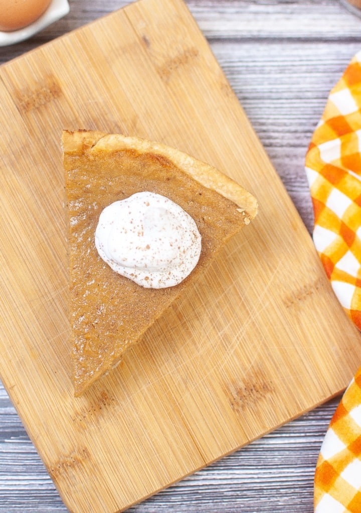 Overhead view of a slice of pie on a cutting board. 