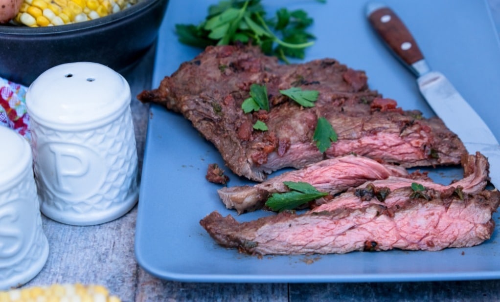 Steak sliced on a blue serving plate.