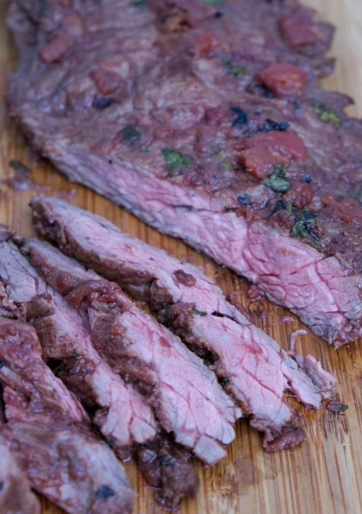 Sliced flank steak on a cutting board. 