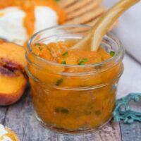 Low sugar peach jam with jalapenos in a small mason jar.