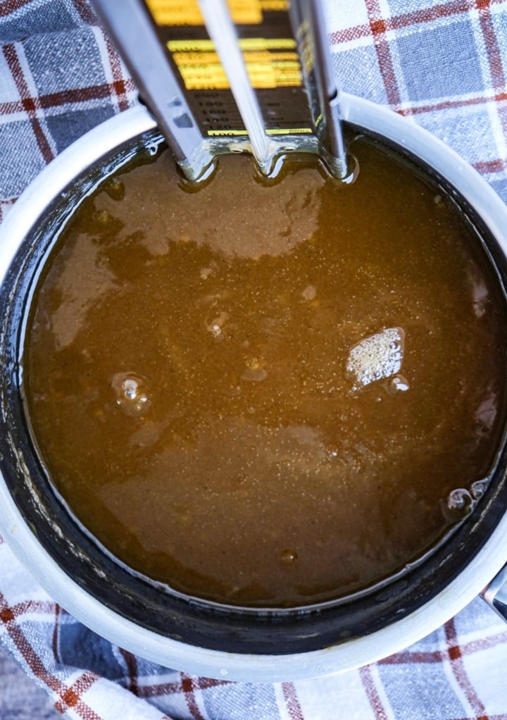 A candy thermometer in a small saucepan waiting for soft ball heat.  