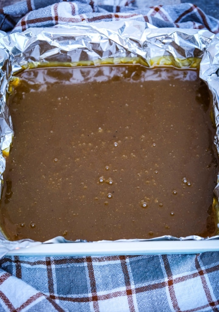 Pumpkin fudge cooling in a square baking pan.