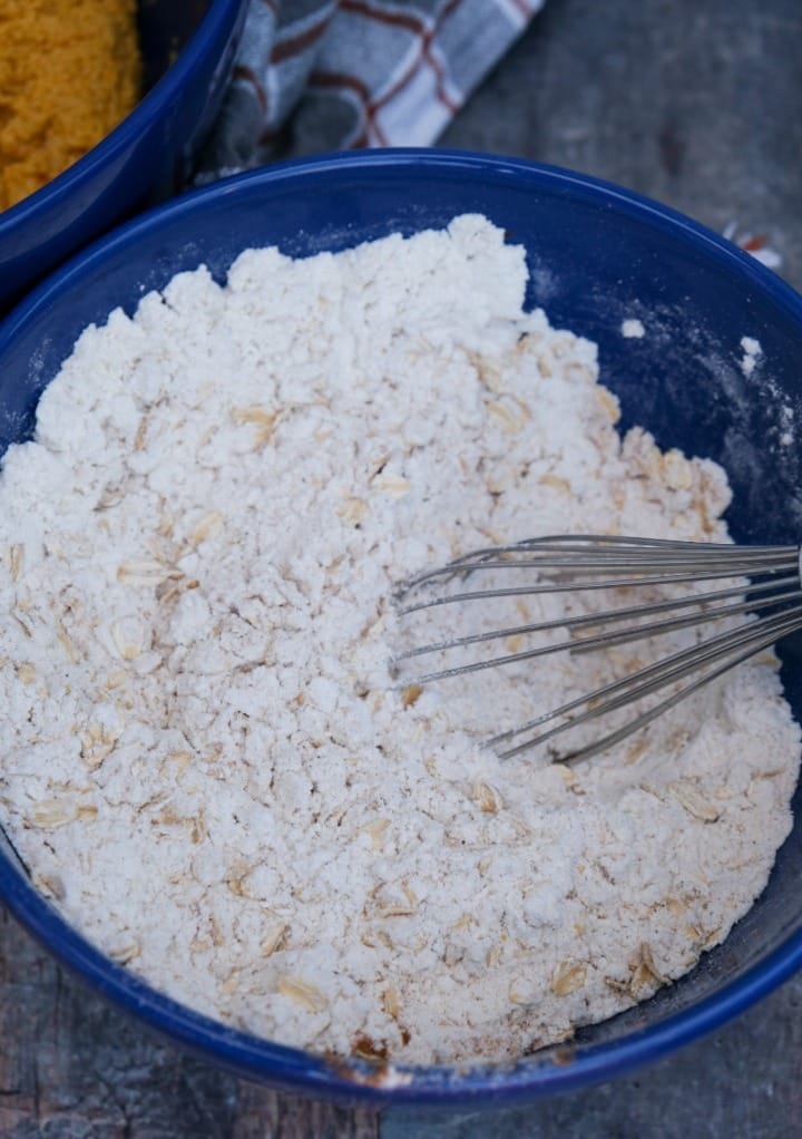 A blue bowl with flour and oats for cookies. 