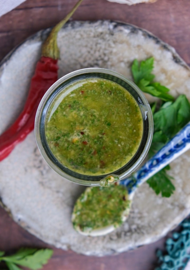 Overhead view of spicy chimichurri sauce recipe with a red pepper on the side. 