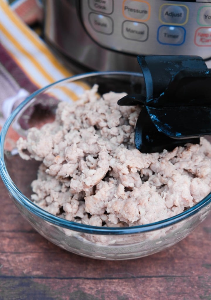 Cooked sausage in a clear mixing bowl. 