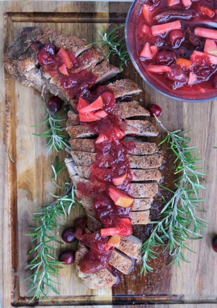 Overhead view of pork loin topped with apple cranberry sauce.