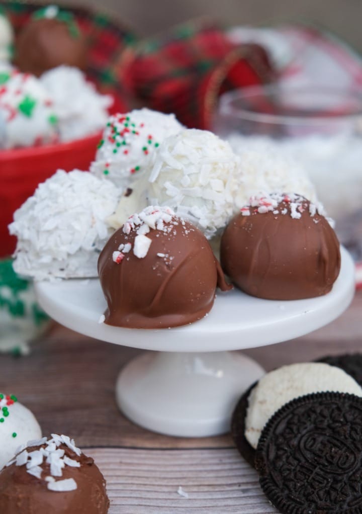 Oreo balls on a small white cake pedestal.  