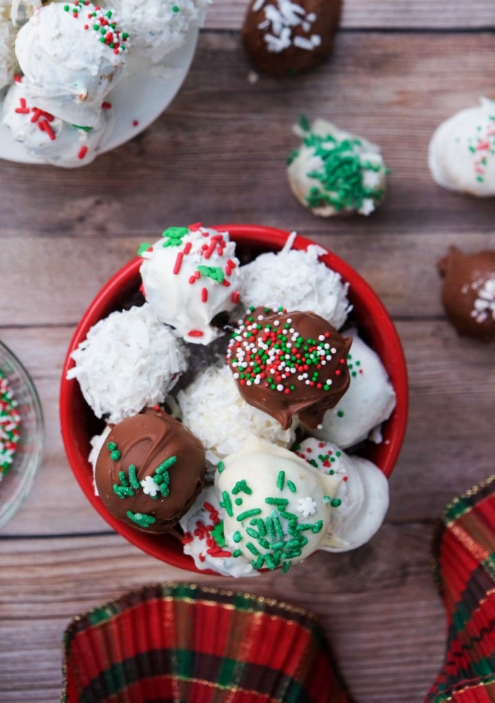 Top view of Oreo balls dipped in white and dark chocolate in a small red bowl. 