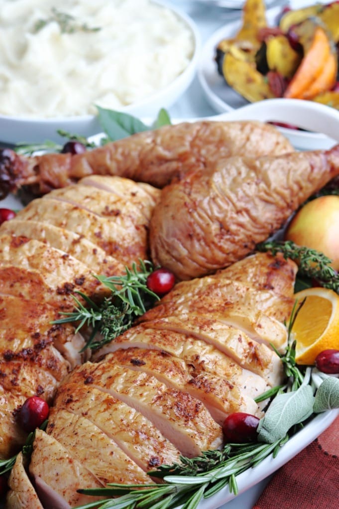 Poultry seasoning on cooked sliced turkey on a platter.