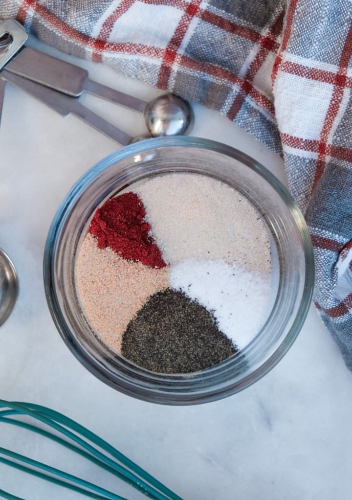 Ingredients to make homemade poultry seasoning in a small glass bowl.