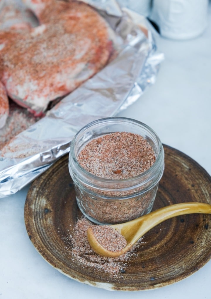 Spices in a small mason jar with the mix sprinkled on chicken before cooking. 