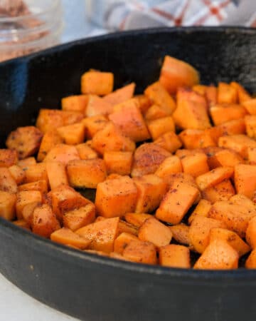Diced sweet potatoes in a cast iron skillet.