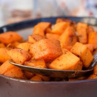 Spoonful of sweet potatoes from a serving bowl.