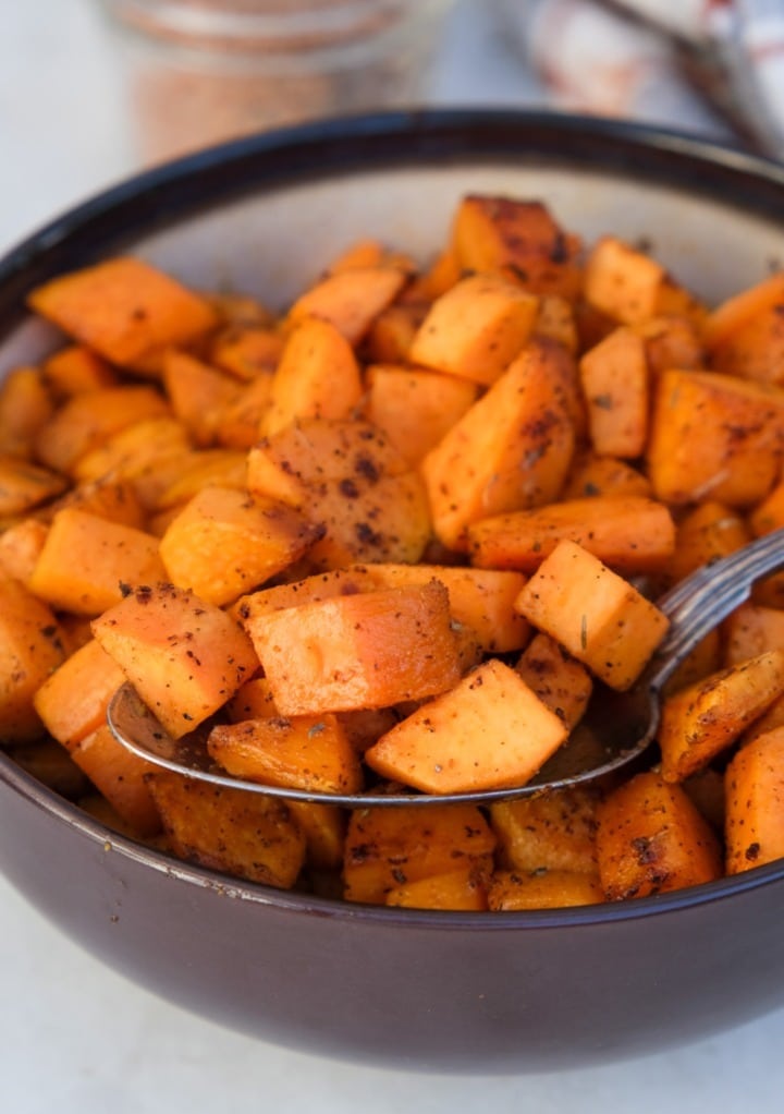 Cubes sweet potatoes in a brown serving bowl. 