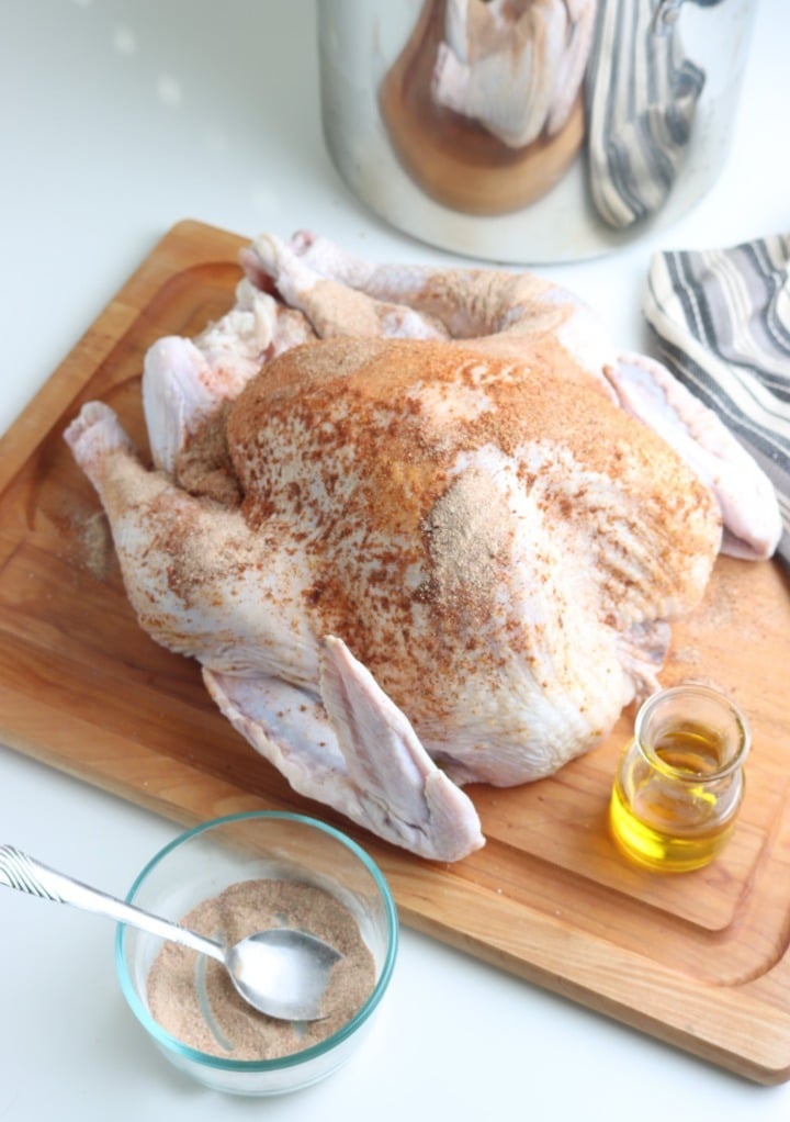 Dry rub over a raw turkey on a cutting board before adding to a smoker to cook. 