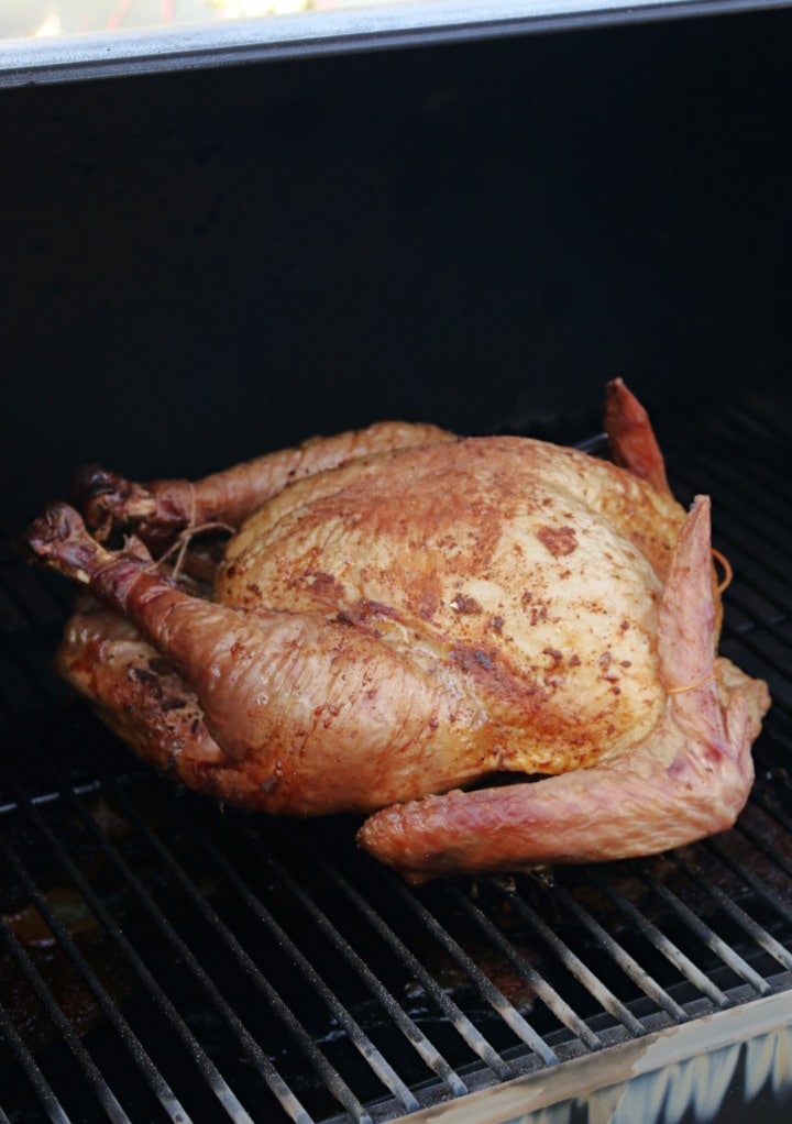 Whole turkey in a smoker cooking. 