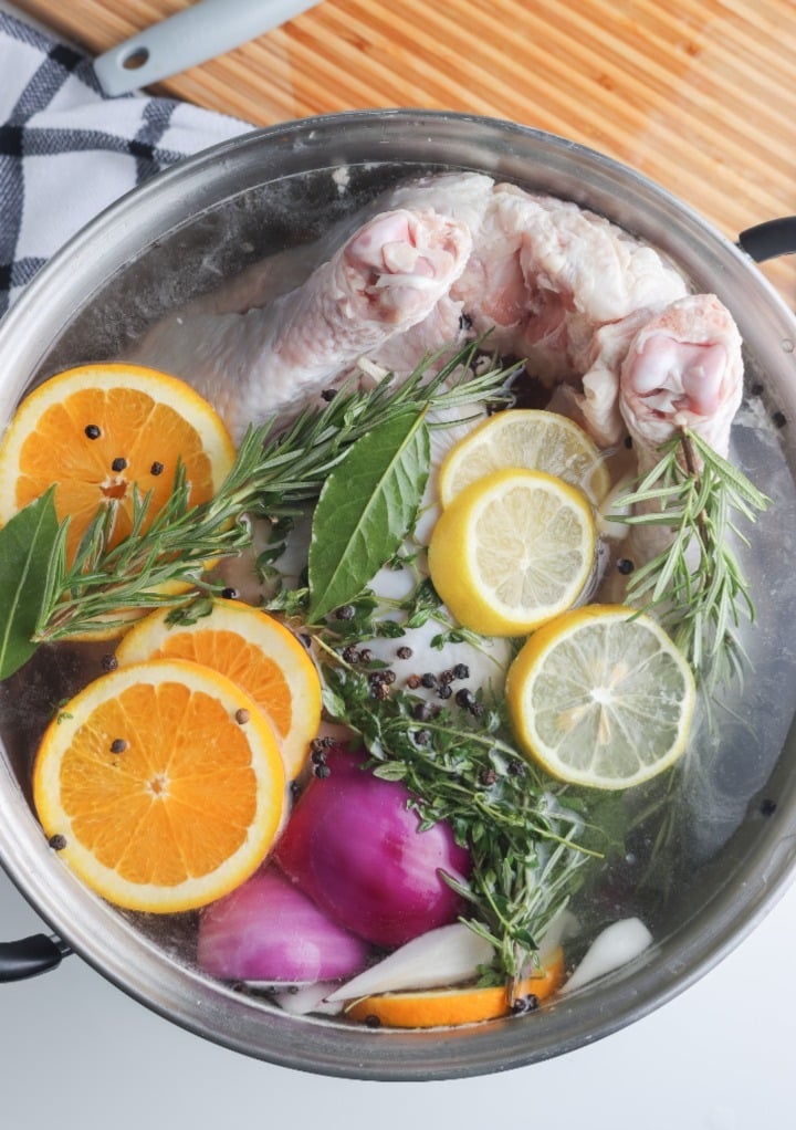 Top view of a whole turkey in a stock pot with a brine mixture. 