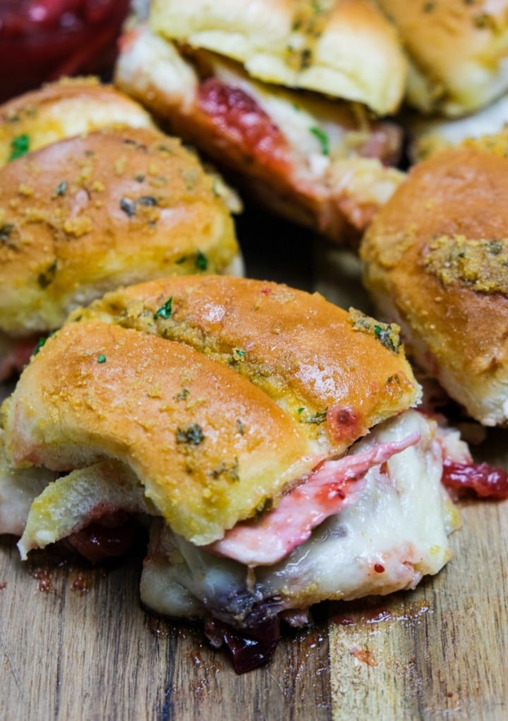 Turkey sliders on a brown cutting board. 