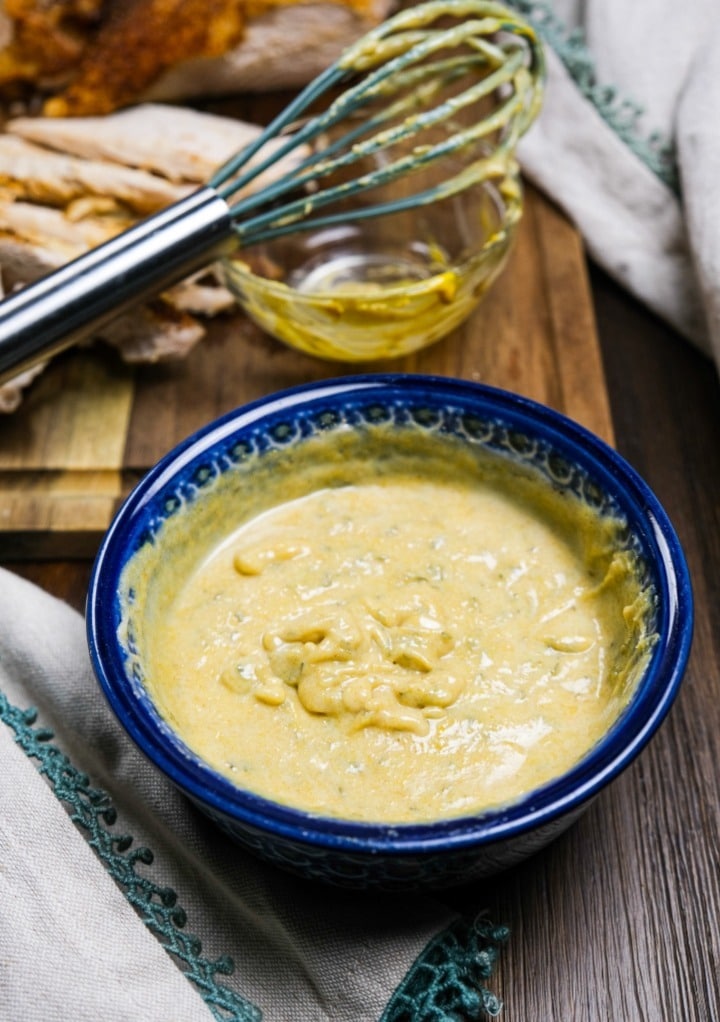 Mustard butter sauce in a small blue mixing bowl. 