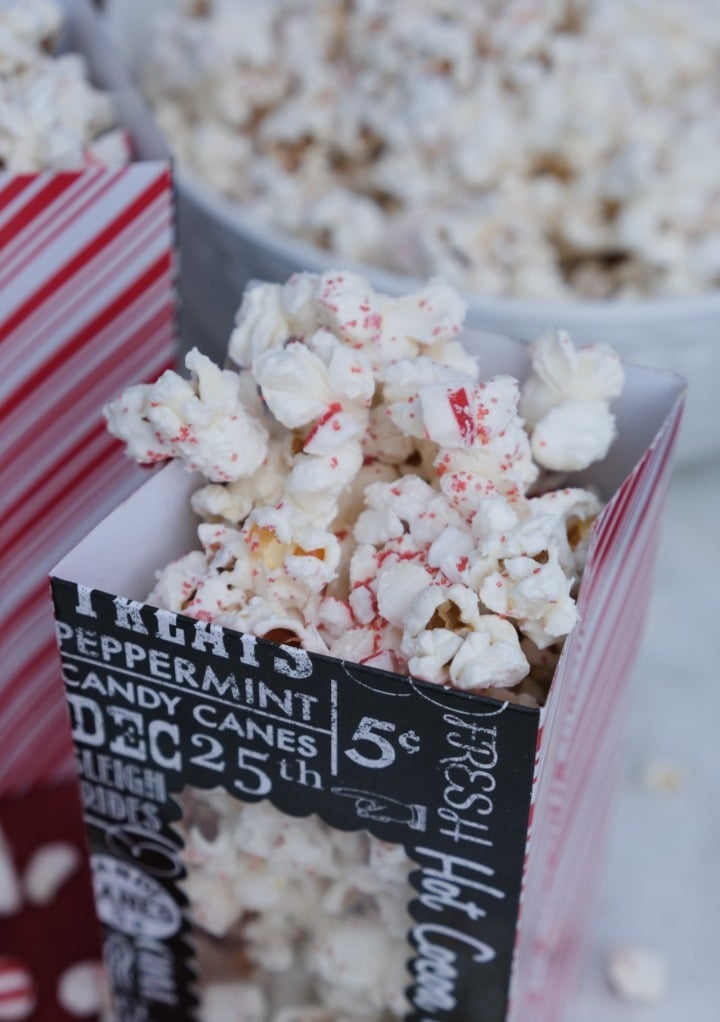 Top view of popcorn coated with white chocolate and peppermint candy in a popcorn bag ready to eat. 