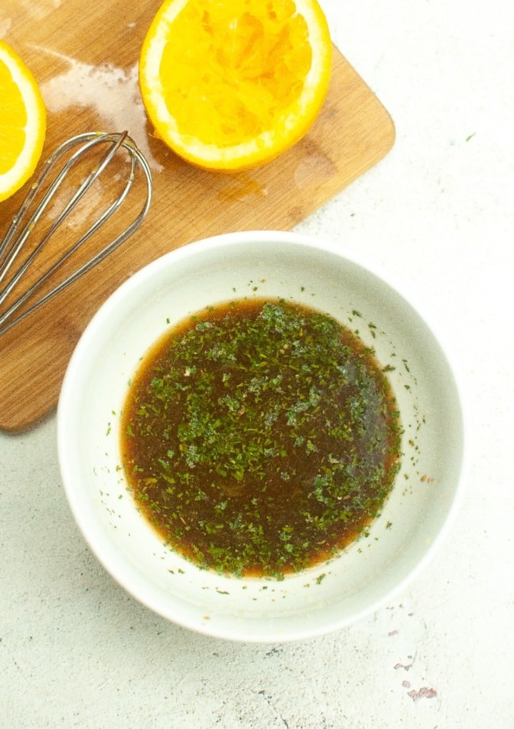 Fresh orange sauce  in a white mixing bowl to add to salmon. 