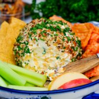 Low carb cheese ball on a serving dish with vegetables and fruit.