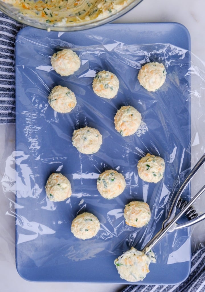Mini cheese balls on a platter before chilling in the refrigerator.