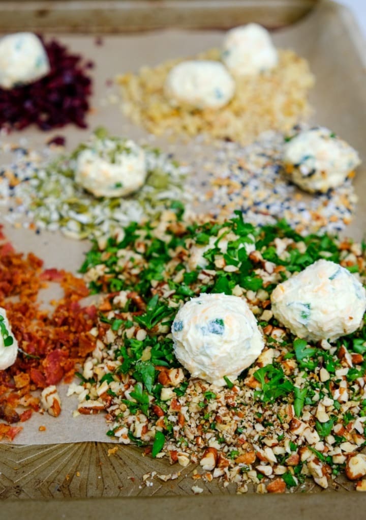 Mini cheese balls ready to roll in a variety of ingredients like bacon bits and chopped nuts.