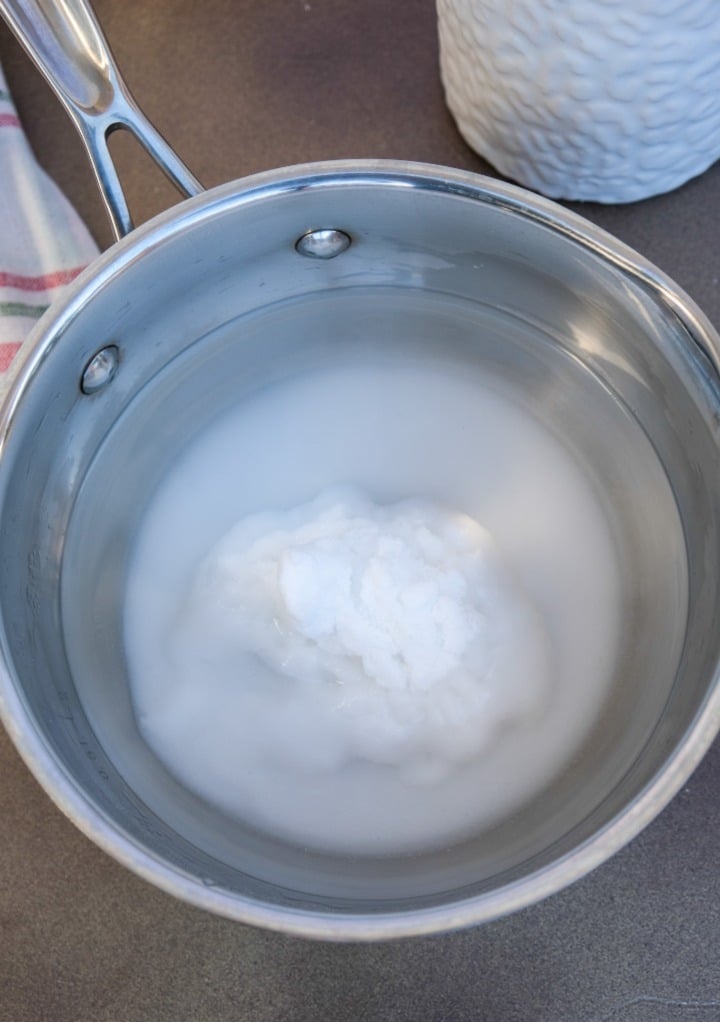 Sugar and water in a small saucepan before simmering. 