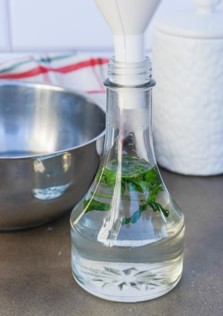 Adding peppermint syrup using a funnel into the jar.