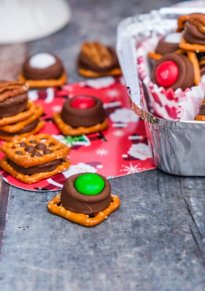 Pretzel pieces with a rolo candy and green m&m ready to eat. 